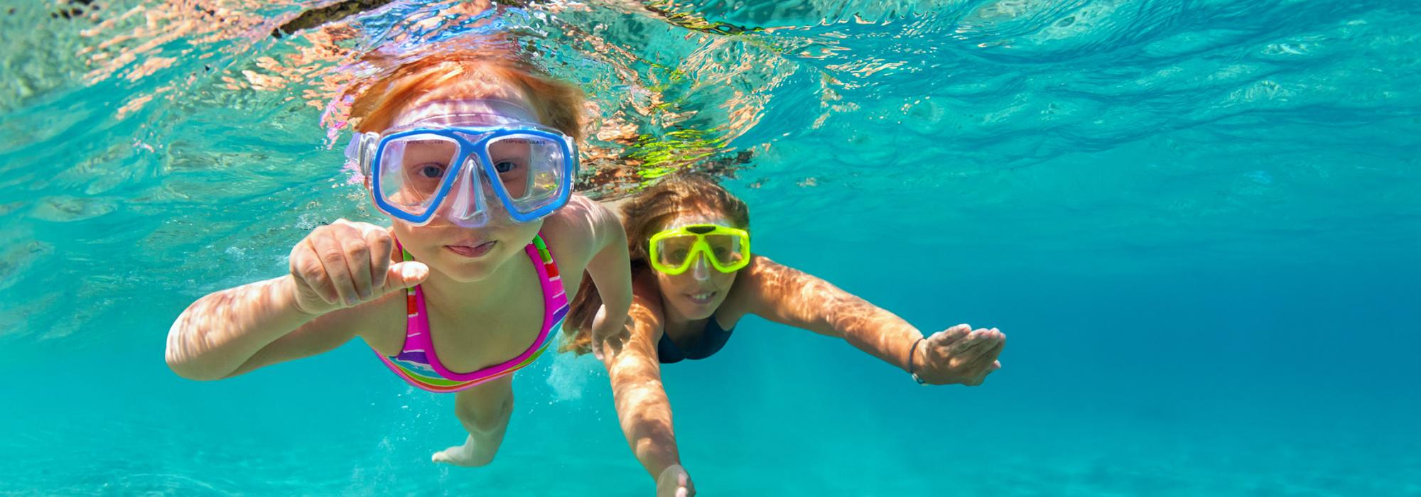 Two kids swimming underwater